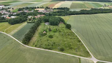 Luftaufnahme des Anwesens, umgeben von Feldern und Wald, mit einem Haus in der Mitte.
