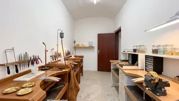 Werkstattraum mit mehreren Holzwerkbänken und Werkzeugen, ideal für handwerkliche Tätigkeiten.