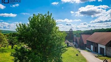 Malerischer Blick über eine ländliche Landschaft mit traditionellen Häusern und grünen Hügeln.