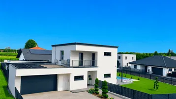 Modernes Einfamilienhaus mit Flachdach, integrierter Garage und gepflegter Außenanlage in sonniger Lage.