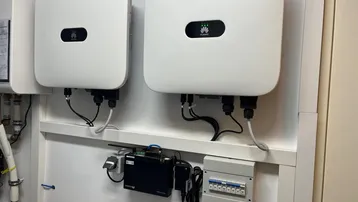 Zwei Wechselrichter für eine Photovoltaikanlage in einem Technikraum installiert.