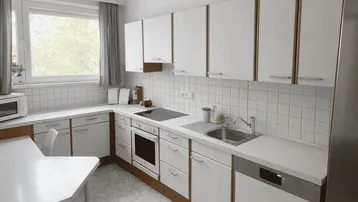 Funktionale Küche mit weißen Schränken, Essbereich und Fenster.