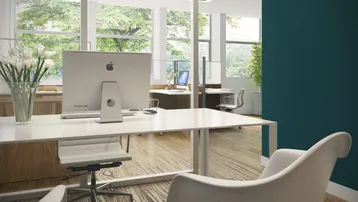 Modernes Büro mit großen Fenstern, die viel Tageslicht hereinlassen und einen Blick ins Grüne bieten.