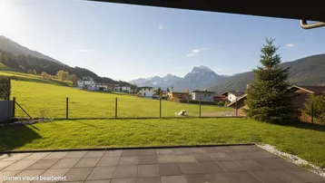 Geräumige Terrasse mit weitem Blick auf grüne Wiesen und die umliegende Berglandschaft.