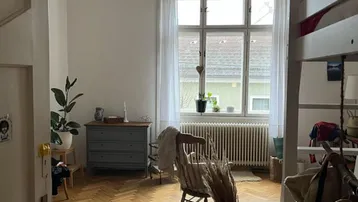 Helles Schlafzimmer mit Fischgrätparkett, Fenster und einem Hochbett, das viel Platz bietet.