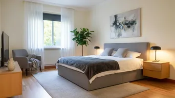 Helles Schlafzimmer mit Holzboden, großem Bett und moderner Kunst an der Wand.