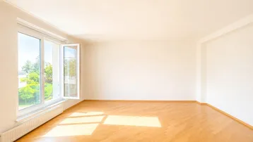 Geräumiges, helles Zimmer mit großen Fenstern und Blick ins Grüne.