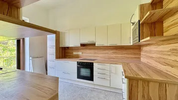 Moderne Küche mit hellen Fronten, Holzoptik-Arbeitsplatten und integriertem Backofen.