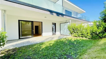 Moderne Wohnanlage mit großer Terrasse und privatem Gartenbereich im Erdgeschoss.