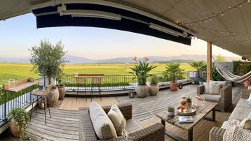 Geräumige Terrasse mit gemütlicher Sitzecke, Hängematte und weitem Blick über Weinberge und Berge.