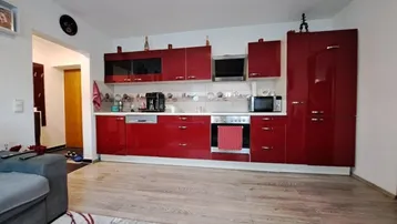 Moderne Einbauküche in leuchtendem Rot mit integrierten Geräten und viel Stauraum.