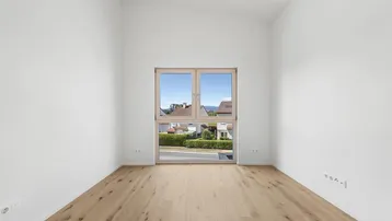 Helles Zimmer mit Holzboden und weitem Blick über die Landschaft und die Berge.