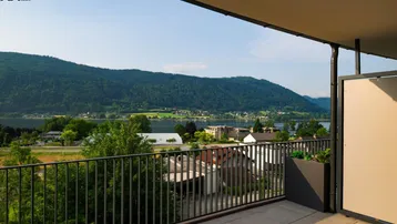 Geräumiger Balkon mit Fliesenboden und atemberaubendem Blick auf den See und die umliegenden Berge.
