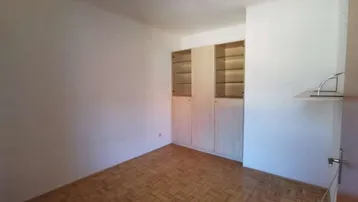 Helles Zimmer mit Parkettboden und Einbauschrank, ideal als Schlaf- oder Arbeitszimmer.