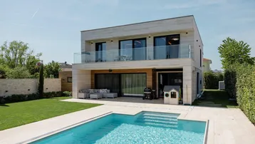 Modernes Haus mit großem Garten, Swimmingpool und Terrasse für entspannte Stunden im Freien.