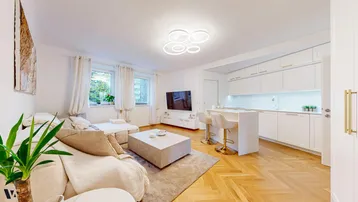 Helles, offenes Wohnzimmer mit integrierter Küche, Parkettboden und modernen Möbeln.