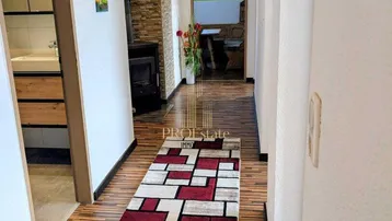 Heller Flur mit modernem Teppichläufer, Holzboden und Steinwandakzenten.