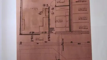 Grundriss einer Wohnung mit Bad, Schlafzimmer und Zugang zu einem Außenbereich.