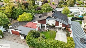 Übersichtliche Luftaufnahme des gesamten Anwesens mit Garten, Garage und Solaranlage auf dem Dach.