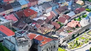 Malerische Luftaufnahme einer historischen Stadt mit Burg, Fluss und grüner Landschaft.