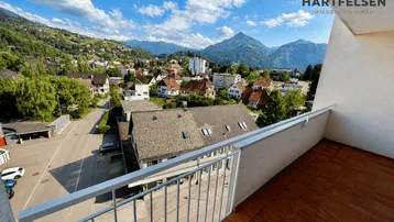 Geräumiger Balkon mit Fliesenboden und weitem Blick über die Stadt und die umliegenden Berge.