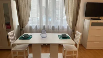 Heller Essbereich mit Esstisch, Stühlen und Blick aus dem Fenster, ergänzt durch einen Kleiderschrank.