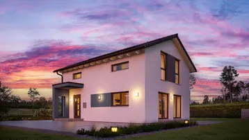 Modernes Einfamilienhaus mit Satteldach und großen Fenstern bei Sonnenuntergang.