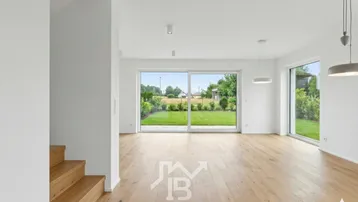Heller Wohnbereich mit Eichenparkett, großen Fensterfronten und direktem Zugang zum Garten.