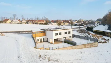 Luftaufnahme des Anwesens mit umliegenden Häusern, Feldern und verschneiter Landschaft.