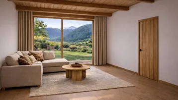 Helles Wohnzimmer mit Ecksofa, Holzbalkendecke und großem Fenster mit Bergblick.