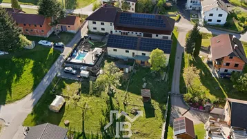 Luftaufnahme des Anwesens mit mehreren Gebäuden, großem Garten und Poolbereich in ländlicher Umgebung.