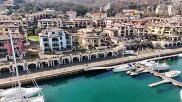Luftaufnahme eines modernen Wohnkomplexes mit Yachthafen und vielen Gebäuden in mediterranem Stil.