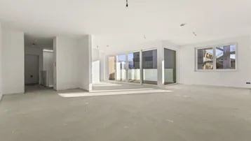 Heller, unmöblierter Wohnbereich im Rohbau mit großen Fensterfronten und Zugang zur Terrasse.