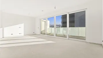 Heller, unmöblierter Wohnbereich im Rohbau mit großen Schiebetüren, die auf einen Balkon oder eine Terrasse führen.