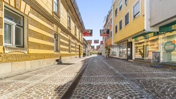 Historische Gasse mit Kopfsteinpflaster und traditionellen Gebäudefassaden in der Stadt.