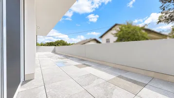 Große, geflieste Terrasse mit weitem Blick und viel Tageslicht, ideal zum Entspannen.