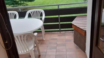 Gemütlicher Balkon mit Gartenmöbeln und Blick ins Grüne, ideal zum Entspannen im Freien.