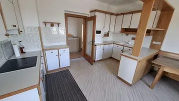 Küche im traditionellen Stil mit weißen Schränken, Holzelementen und integrierter Mikrowelle.