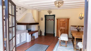 Rustikaler Eingangsbereich mit großem Kamin, Terrakottaboden und traditionellen Holzmöbeln.