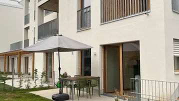 Moderne Wohnanlage mit privater Terrasse und Gartenbereich im Erdgeschoss.