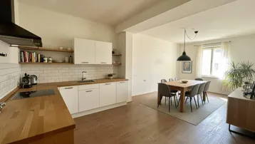 Heller offener Wohn- und Essbereich mit moderner Küche und Holzboden.