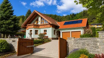 Charmantes Einfamilienhaus mit gepflegtem Vorgarten, Doppelgarage und Solaranlage auf dem Dach.