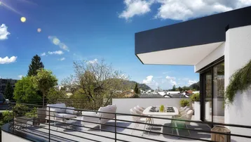 Geräumige Terrasse mit modernen Gartenmöbeln und weitem Blick über die Umgebung unter blauem Himmel.