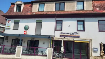 Ansicht der Gebäudefassade mit einem Café und Restaurant im Erdgeschossbereich und traditioneller Architektur.