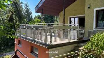 Große Terrasse mit Metallgeländer und Blick ins Grüne, ideal für entspannte Stunden im Freien.