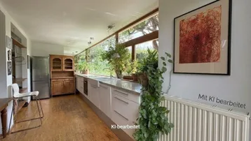 Helle Küche mit langen Fensterfronten, Granitarbeitsplatte und Holzboden.