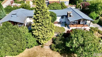Luftaufnahme eines Einfamilienhauses mit großem Garten und viel Grünfläche.
