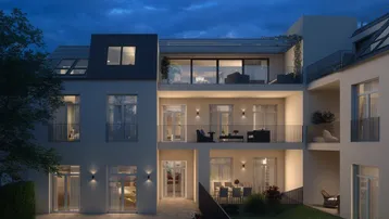 Moderne Wohnanlage bei Nacht mit beleuchteten Balkonen, Terrassen und einem gepflegten Gartenbereich.