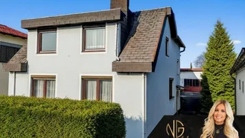 Gepflegtes Einfamilienhaus mit Satteldach, Rollläden und einer hohen Hecke im Vorgarten.