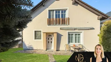 Einfamilienhaus mit gepflegtem Vorgarten, kleiner Terrasse und französischem Balkon im Obergeschoss.